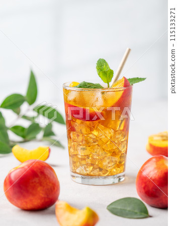 Refreshing peach iced mint tea close up. The concept of a healthy homemade cold summer drink Refreshing peach iced mint tea close up. The concept of a healthy homemade cold summer drink 115133271