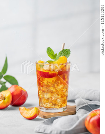 Refreshing peach iced mint tea. The concept of a healthy homemade cold summer drink Refreshing peach iced mint tea. The concept of a healthy homemade cold summer drink 115133295