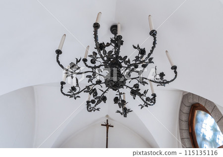 black vintage hanging chandelier in Gothic style on ceiling in a Catholic Church 115135116