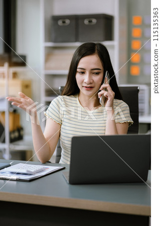 Businesswoman talk mobile phones and working on laptop computers, online business. Businesswoman talk mobile phones and working on laptop computers, online business. 115135363