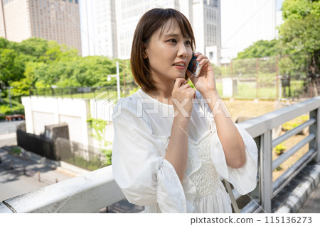 Woman talking on smartphone outdoors Woman talking on smartphone outdoors 115136273