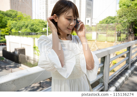 Woman talking on smartphone outdoors Woman talking on smartphone outdoors 115136274
