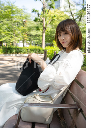 一名婦女坐一條室外長凳 115136277