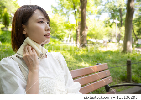 坐在戶外長椅上擦汗的女人 115136295