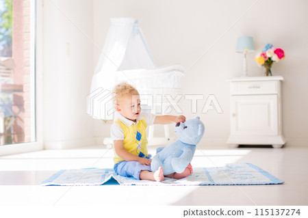 Little boy playing with toy teddy bear. Kids play. 115137274