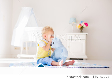 Little boy playing with toy teddy bear. Kids play. Little boy playing with toy teddy bear. Kids play. 115137277