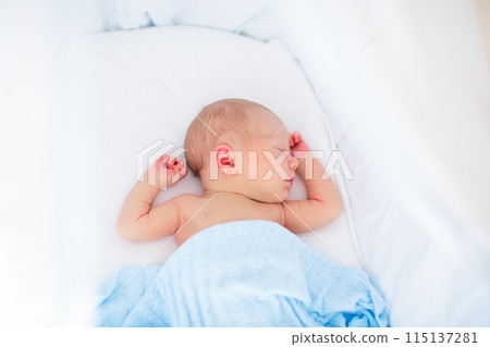 Little baby on white bed 115137281
