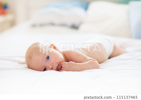 Little baby on white bed 115137465
