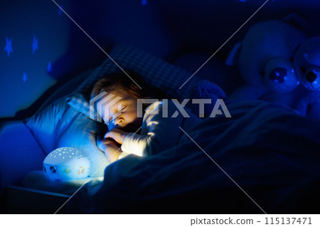 Little girl reading a book in bed 115137471