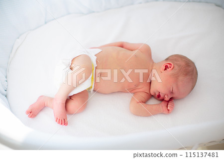 Little baby on white bed 115137481