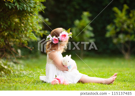 Little girl with flower bouquet in sunny garden 115137485