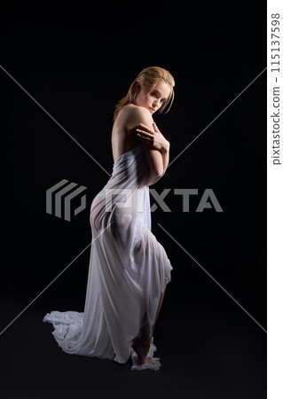 Sensual woman in white fabric in black studio Sensual woman in white fabric in black studio 115137598