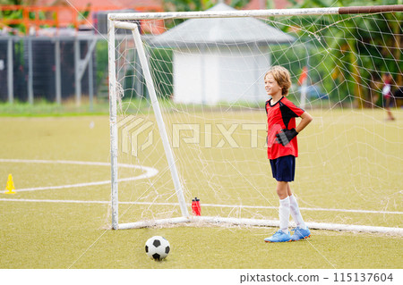 Kids play football. Child at soccer field. Kids play football. Child at soccer field. 115137604