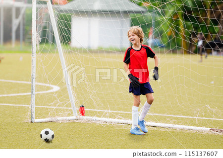 Kids play football. Child at soccer field. 115137607