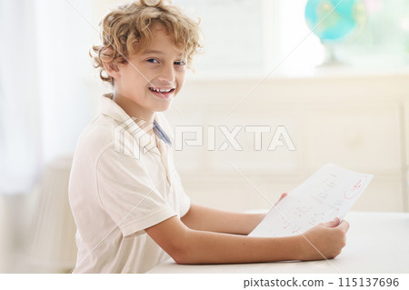 Child holding school test with excellent A grade. Child holding school test with excellent A grade. 115137696