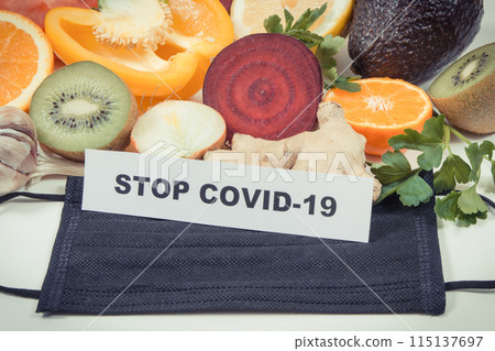 Inscription stop covid-19, fresh fruits with vegetables and protective mask Inscription stop covid-19, fresh fruits with vegetables and protective mask 115137697