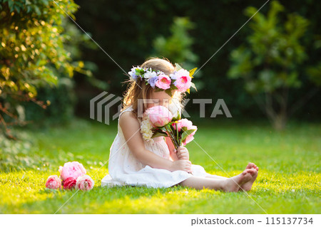 Little girl with flower bouquet in sunny garden Little girl with flower bouquet in sunny garden 115137734