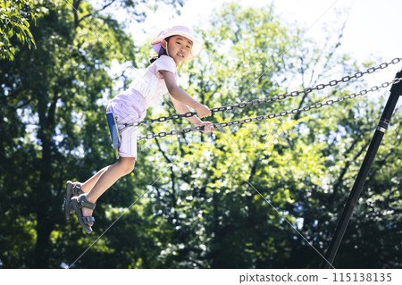 Elementary school student playing with a swing 115138135