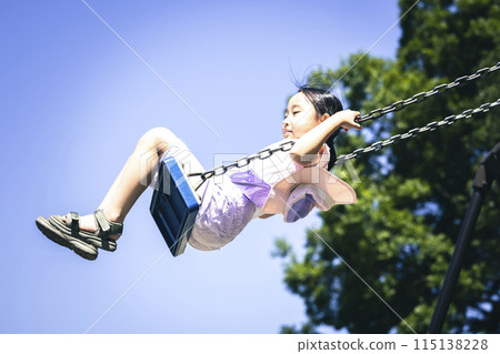 Elementary school student playing with a swing 115138228