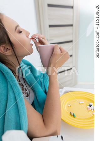 On the plate lies a set of tablets and vitamins as well as antibiotics that are necessary during every illness and cold. 115138626