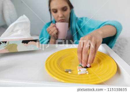 On the plate lies a set of tablets and vitamins as well as antibiotics that are necessary during every illness and cold. On the plate lies a set of tablets and vitamins as well as antibiotics that are necessary during every illness and cold. 115138635