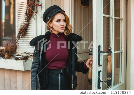 Beautiful pensive woman with black leather jacket standing on the city street 115138884