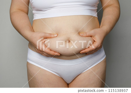 Woman holding her stomach close up 115138937