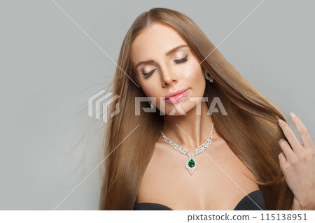 Posing glamorous woman with brown hair, makeup and gold jewelry closeup fashion beauty portrait 115138951