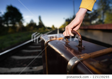 Not a safe walk on the tracks with an old travel suitcase at sunset on hot summer days. Not a safe walk on the tracks with an old travel suitcase at sunset on hot summer days. 115139293