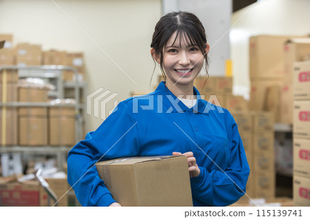 倉庫裡有紙板的年輕女子 倉庫裡有紙板的年輕女子 115139741