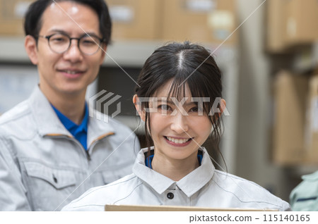 穿著工作服的男女工人拿著紙板 穿著工作服的男女工人拿著紙板 115140165