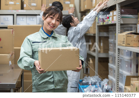 穿著工作服的女人拿著紙箱 穿著工作服的女人拿著紙箱 115140377