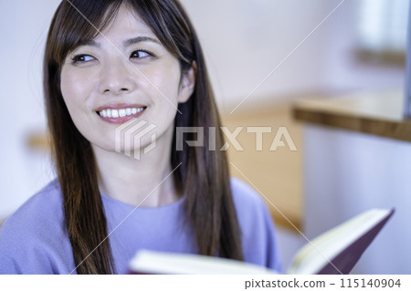 讀一本書的婦女在客廳 115140904