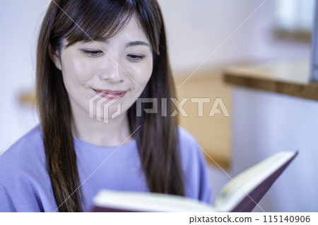 讀一本書的婦女在客廳 115140906