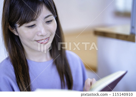 讀一本書的婦女在客廳 115140910