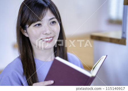 A woman reading a book in the living room A woman reading a book in the living room 115140917
