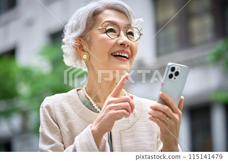 操作智慧型手機的典雅的資深婦女 115141479