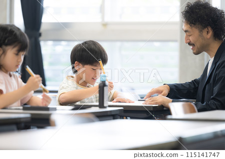 An elementary school boy learning calligraphy in a bright elementary school classroom 115141747
