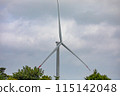 Wind turbine farm in green foliage under cloudy sky, promoting renewable energy 115142048