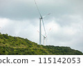 Wind turbines create a serene scene in a verdant landscape under an overcast sky 115142053