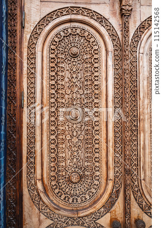 oriental arab pattern Uzbek traditional ornament on wooden carved door in Tashkent in Uzbekistan closeup 115142568
