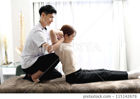 一名男子正在為一名女病人進行按摩治療 115142678
