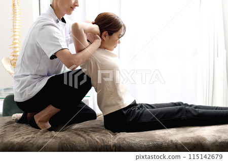 A man giving a massage to a female patient 115142679