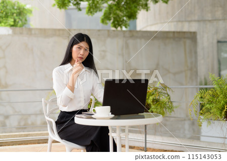 Young woman working on laptop at outdoor terrace cafe with coffee, business concept Young woman working on laptop at outdoor terrace cafe with coffee, business concept 115143053