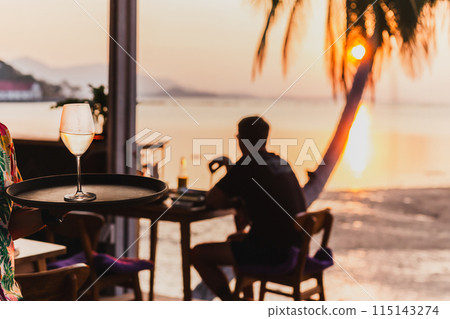 Waiter seaving glass of white wine on a tray. 115143274