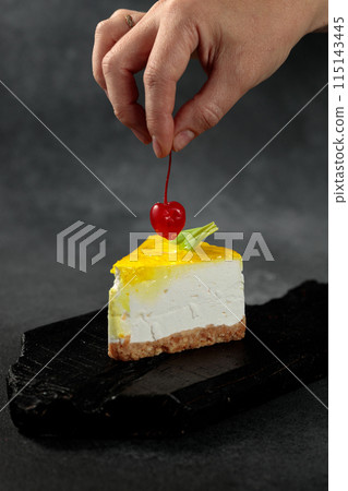 Lemon cheesecake with cherry. On a black background 115143445