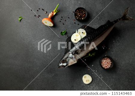 Dried mackerel herring on a black cutting board on a black background Dried mackerel herring on a black cutting board on a black background 115143463