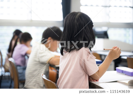 Multiple faceless elementary school students studying in a bright classroom. Great for preparing for exams, cram schools, and studying at school. Multiple faceless elementary school students studying in a bright classroom. Great for preparing for exams, cram schools, and studying at school. 115143639