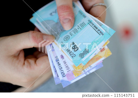 Woman hand with indian rupees bills close up. Concept of financial operations in cash in India 115143751