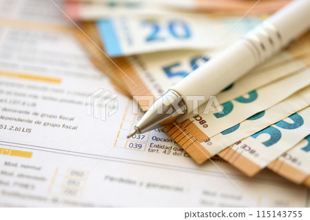 Filling italian tax form process with pen and euro money bills close up. Tax paying period and deadline 115143755